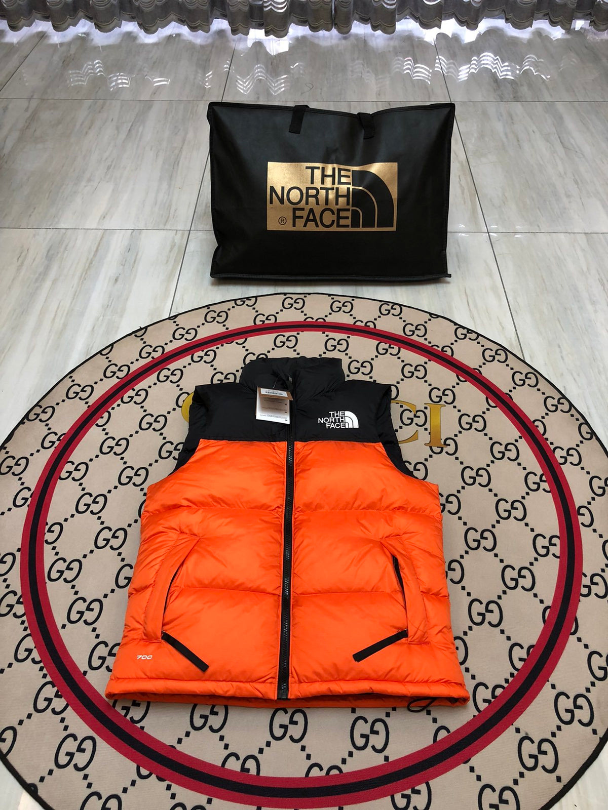 The North Face Puffer Vest in Orange and Black with Stand Collar