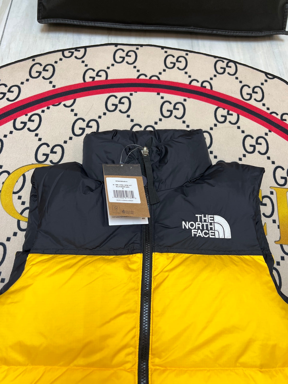 The North Face Puffer Vest in Yellow and Black with Stand Collar